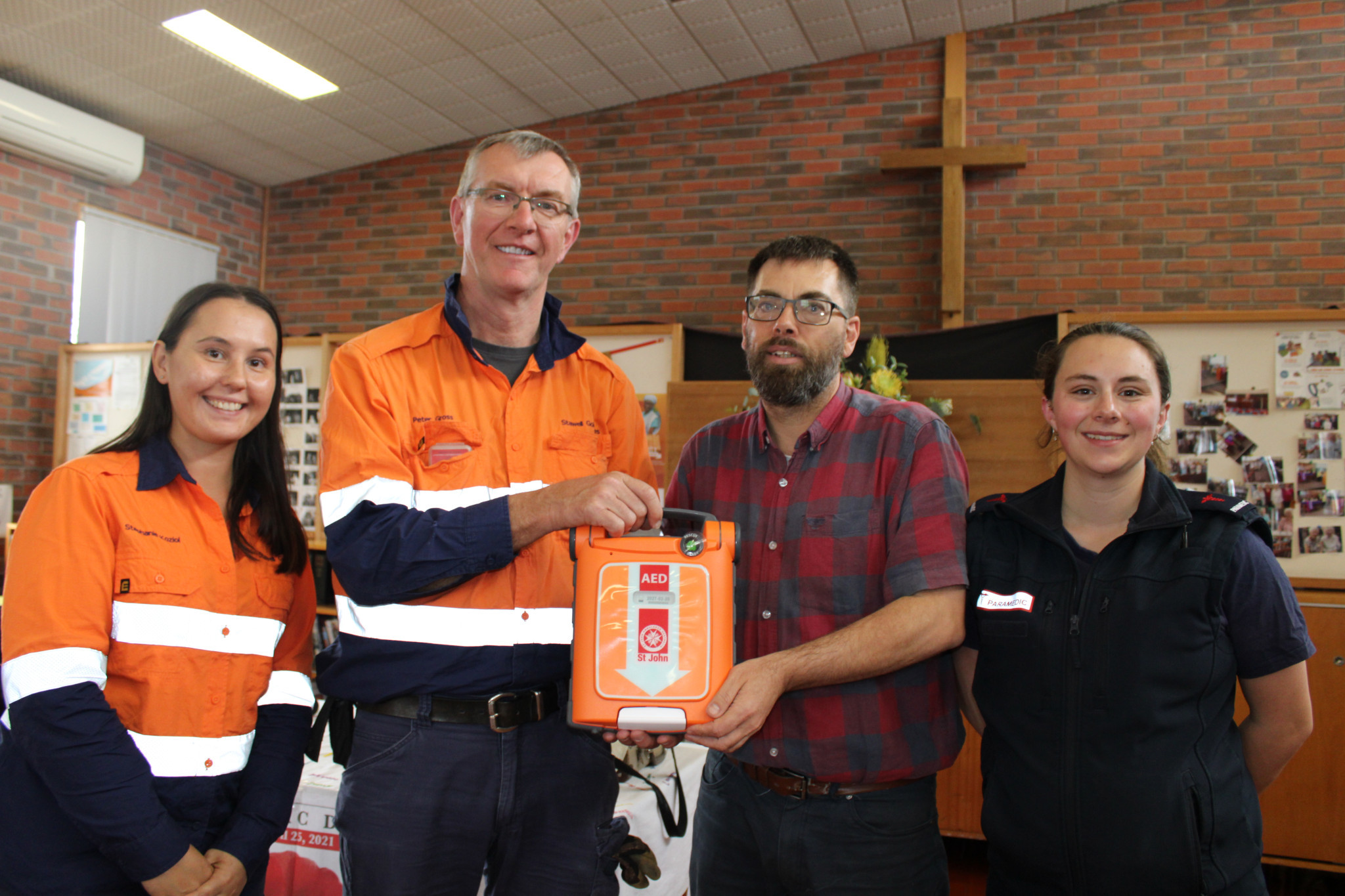 Stephanie Koziol and Peter Goss from Stawell Gold Mine present Uniting Church's new AED Defibrillator to minister Damian Tann, alongside Ambulance Victoria's Hannah Schmidt.