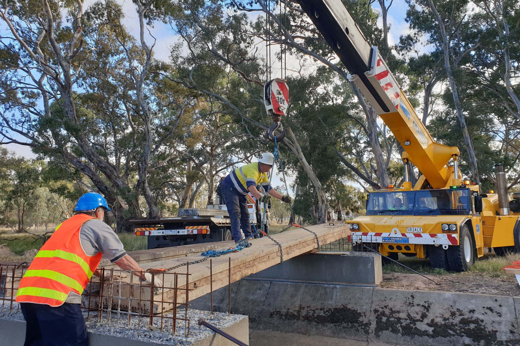 Installing concrete panels onto footings across Pleasant Creek culvert.
