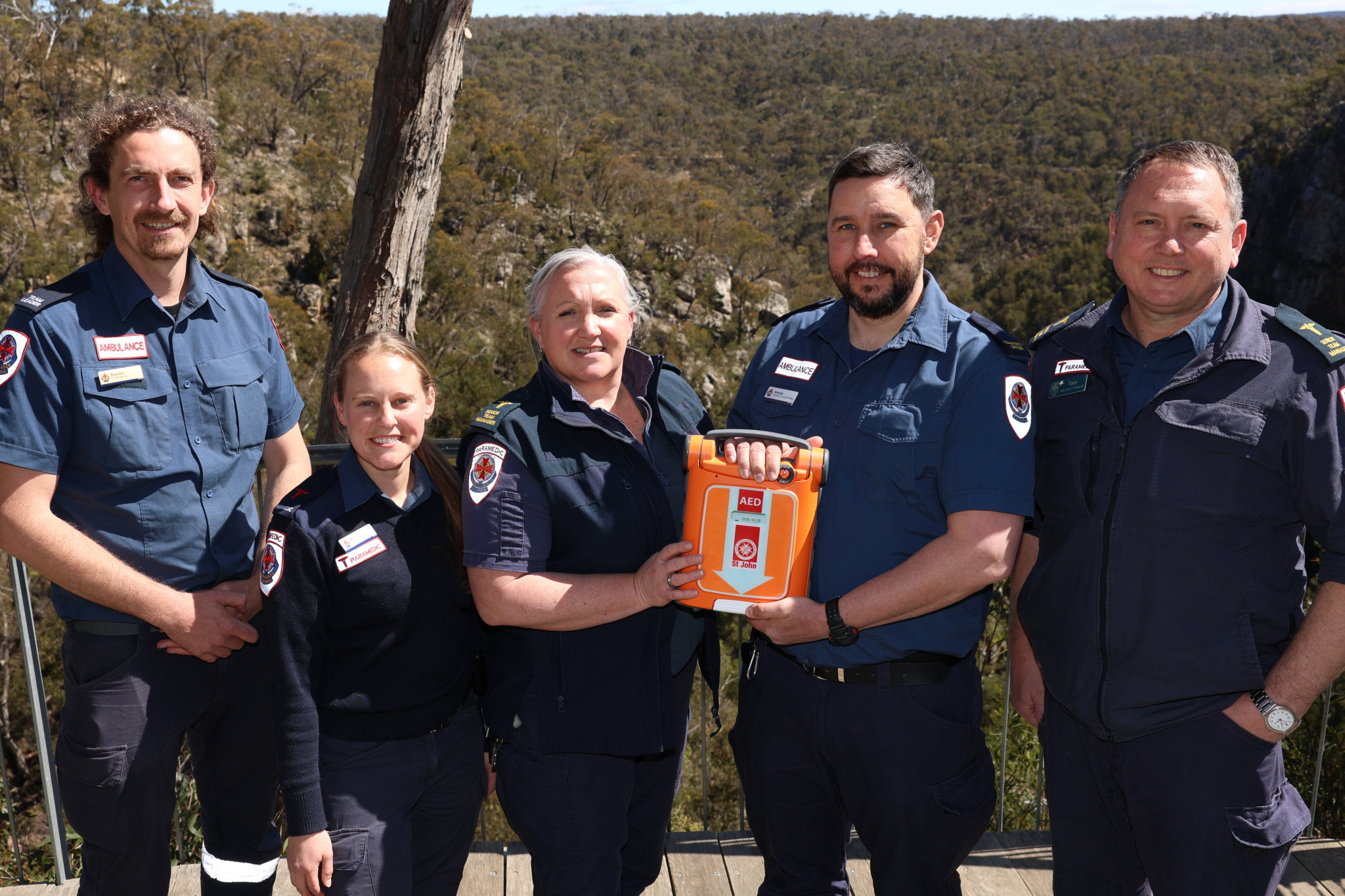 HG AMBOS 01 - Ambulance Victoria's Halls Gap branch has trained 157 people in the town as part of a cardiac arrest campaign in conjunction with The Heart Foundation. AV members with a new automated external defibrillator at MacKenzie Falls from left: Braeden Hyland, Mia Whytecross, Trish Hayes, Brendan Auld and Tony Murrell.
