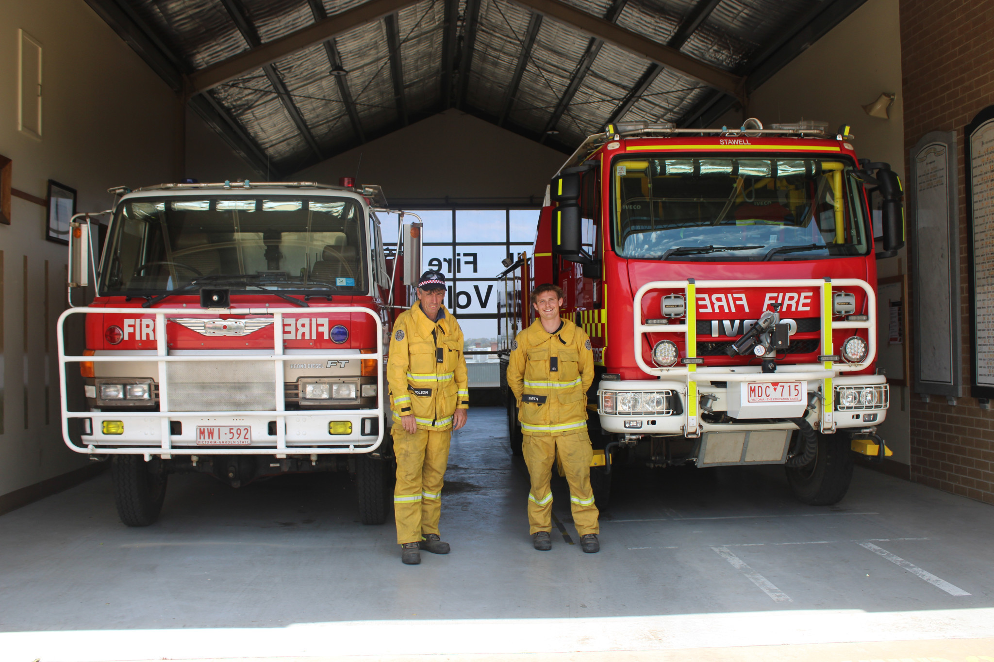 Stawell Fire Brigade captain Mal Nicholson and firefighter Jai Smith stand in front of their two trucks. On the left, a 35-year-old truck, which is used as a backup during fire season, and on the right, their main truck.