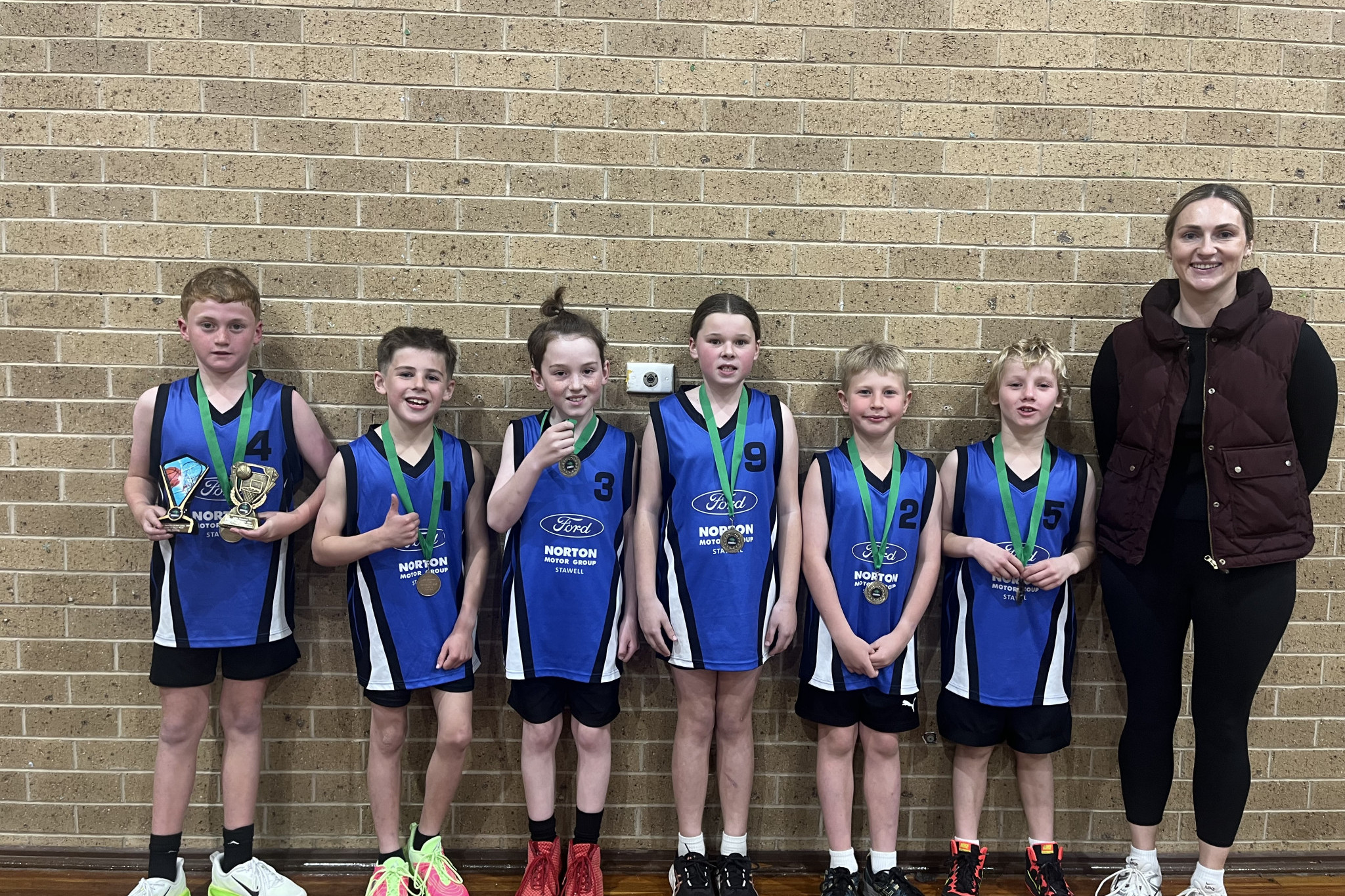 The 2025 under-12 premiers Norton Ford Blue. L-R: Billy Delahunty, Rex Homden, Banjo Crone, Selina Walker, Angus Hughes, David Duxson, Lauren Homden (Coach).