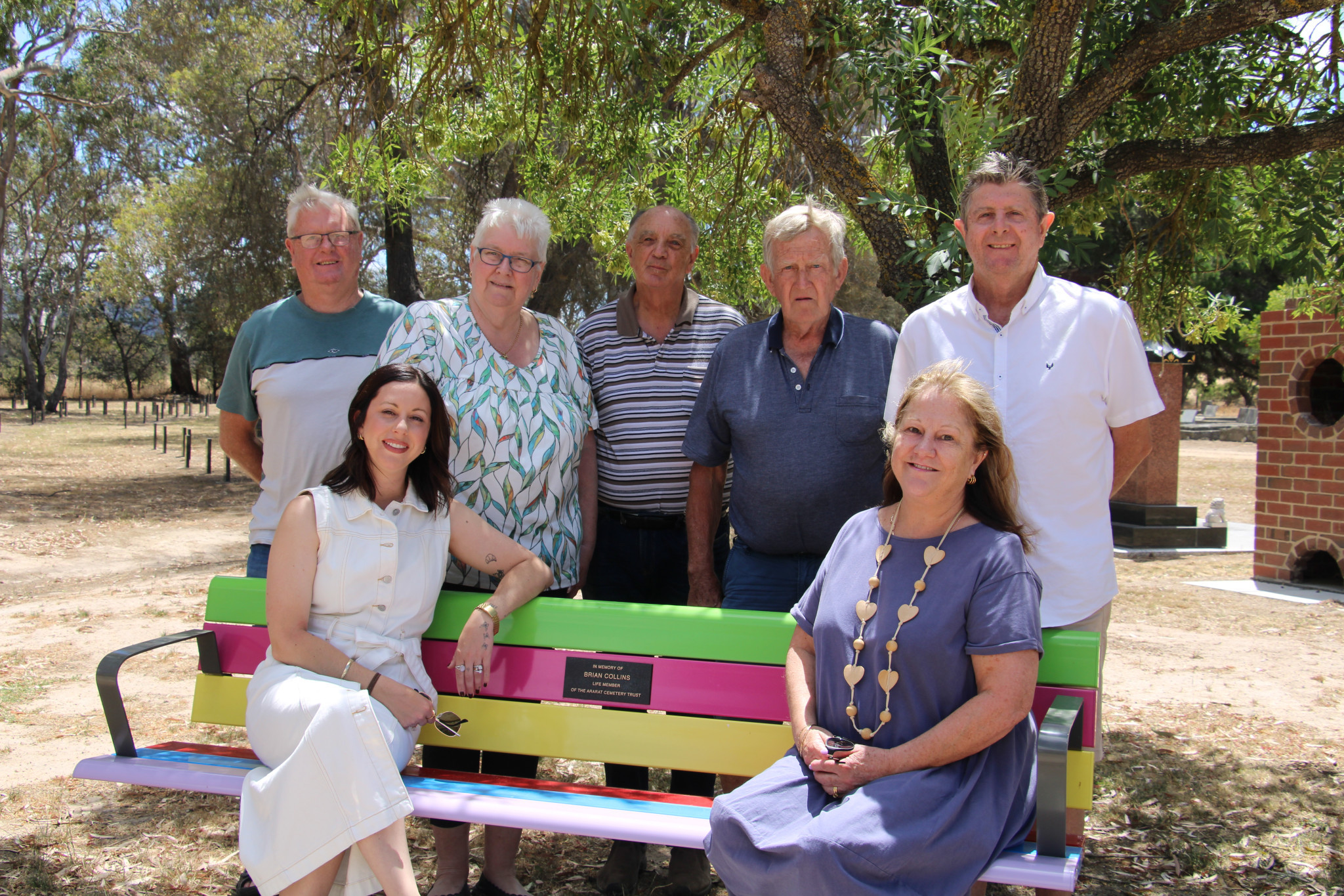 Ken and Ellen Ferrier, Micheal Watson, Les Ralph, Phil Clark, and Sam Parker(front) and Leanne Clark (front) unveil the Brian Collins Bench this week at the Ararat Cemetery.