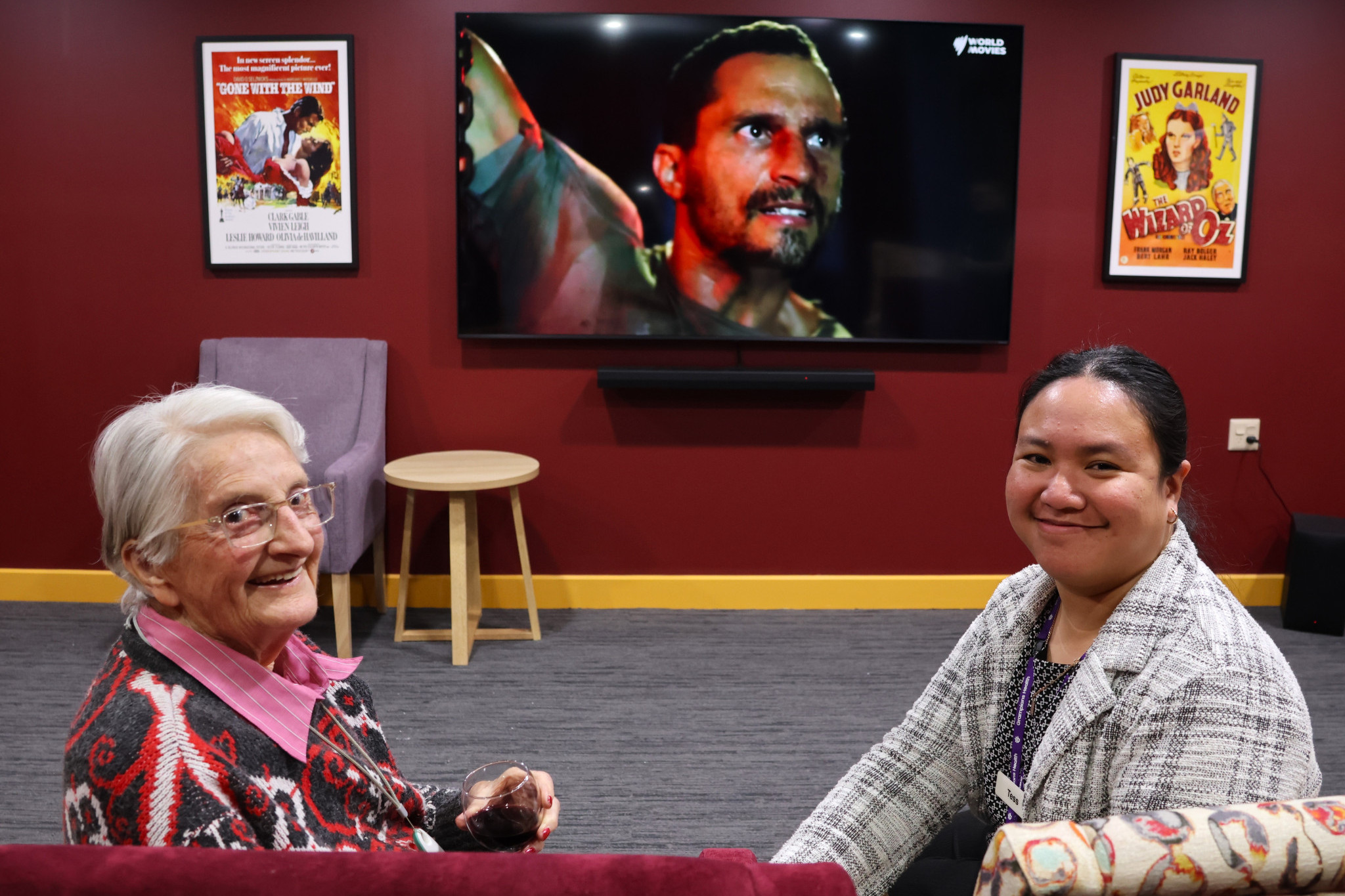 Care Community manager Tess Beniga, right, enjoys a movie with MacPherson Smith resident Barbara.